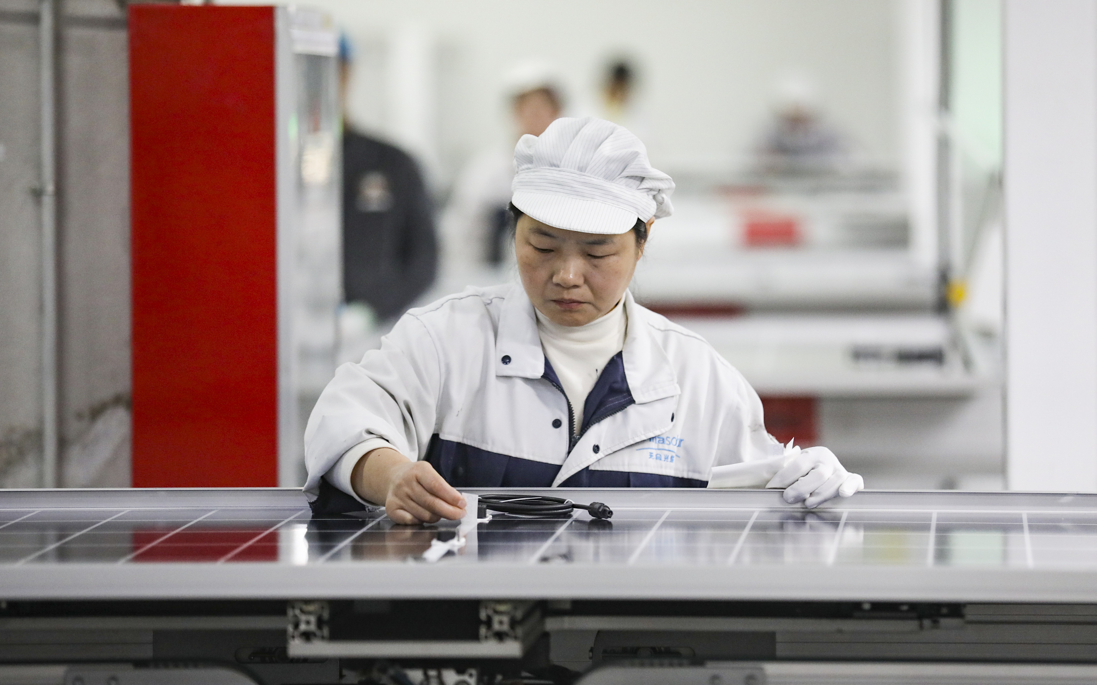 Funcionário trabalha na linha de produção de painéis solares em uma oficina da Trina Solar, em 3 de janeiro de 2025, em Huai’an, na província de Jiangsu, na China