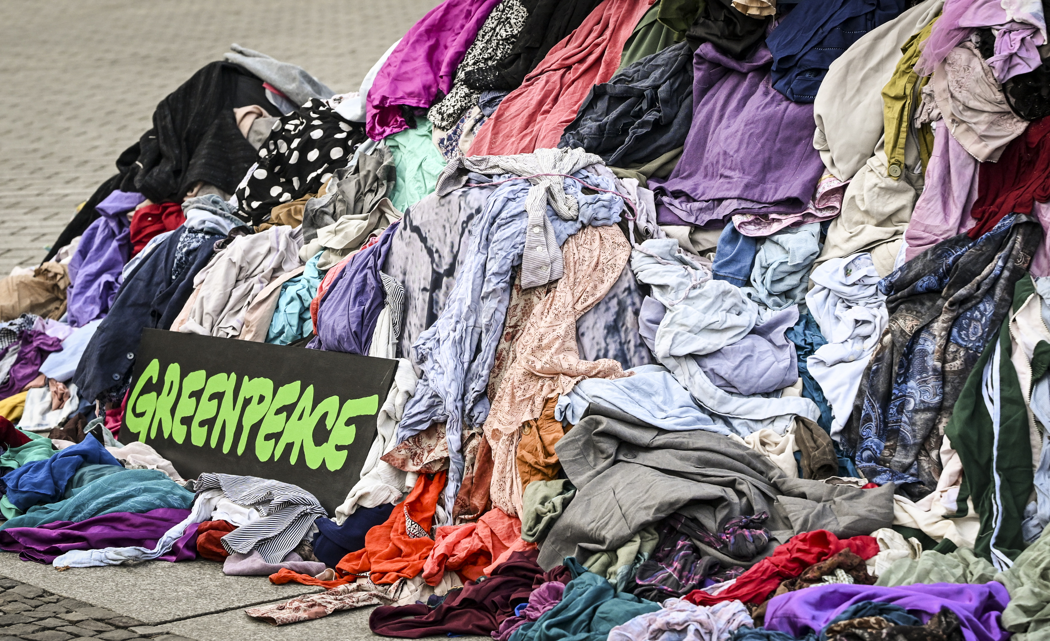 Greenpeace protesta contra o consumismo na moda com roupas descartadas em frente ao Portão de Brandemburgo, em Berlim, em outubro de 2025