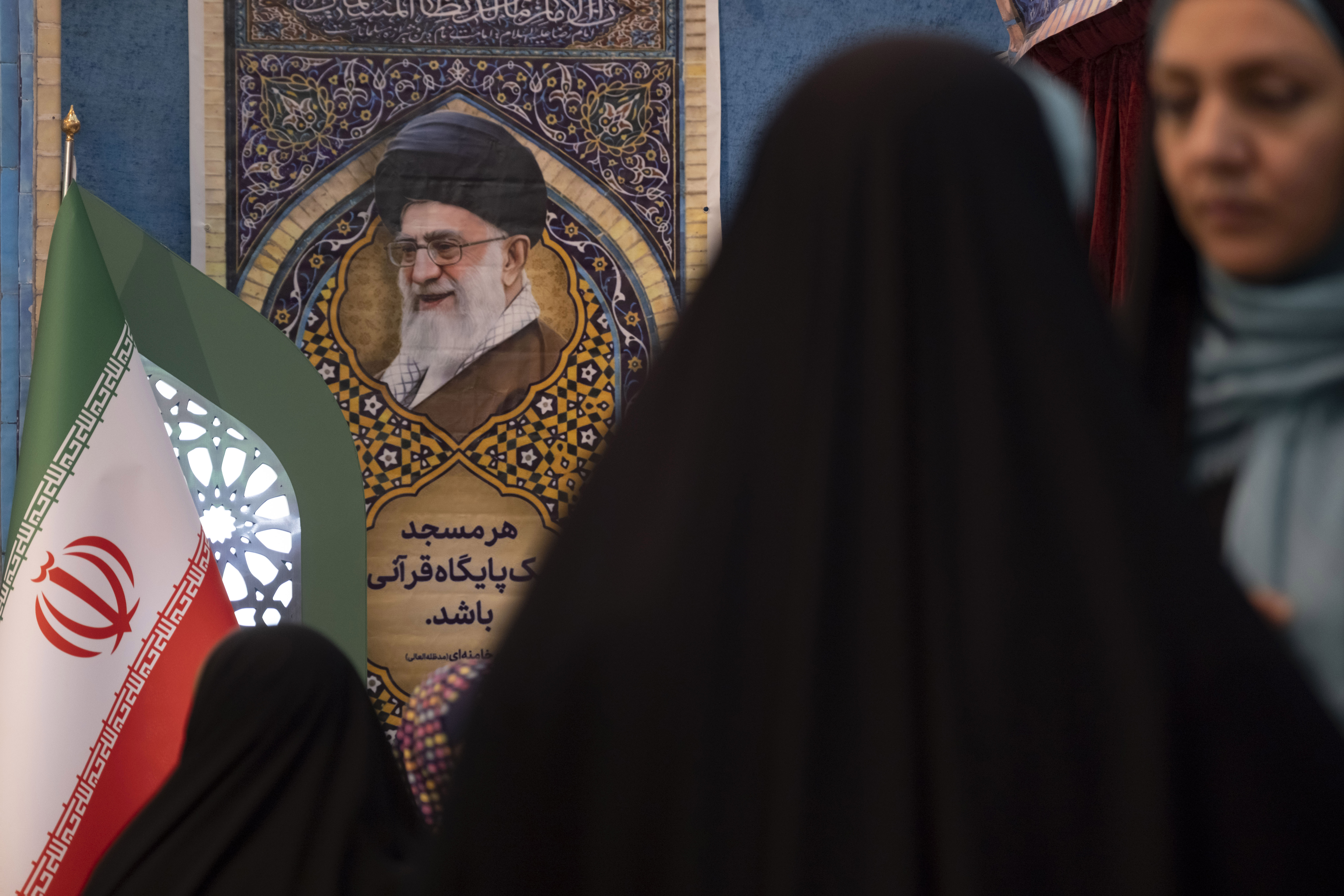 Iranianas observam um retrato do líder supremo do Irã, o aiatolá Ali Khamenei, na Grande Mesquita Imam Khomeini, durante a Exposição Internacional do Alcorão em comemoração ao mês sagrado do Ramadã, no centro de Teerã, Irã, em 21 de fevereiro de 2026