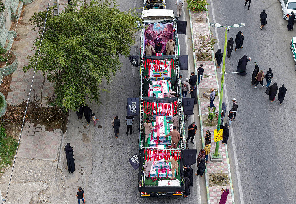MINAB, IRAN - MARCH 03: An aerial view of coffins draped with Iranian flags during a funeral ceremony for children, who lost their lives after a primary school in Iran&acirc;s Hormozgan province was targeted in US and Israeli attacks, on March 03, 2026 in Minab, Iran. Thousands of people, including families and officials, attended the ceremony. (Photo by Stringer/Anadolu via Getty Images)