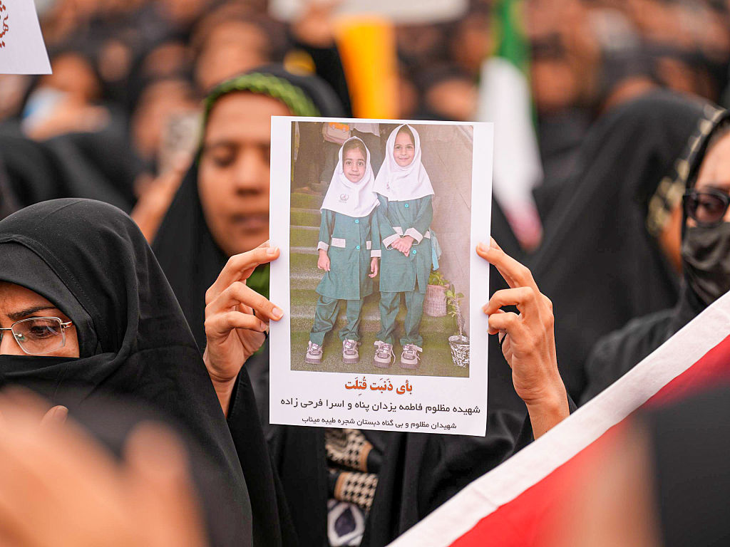 MINAB, IRAN - MARCH 03: Mourners hold a portrait of a students during a funeral ceremony for children, who lost their lives after a primary school in Iranâs Hormozgan province was targeted in US and Israeli attacks, on March 03, 2026 in Minab, Iran. Thousands of people, including families and officials, attended the ceremony. (Photo by Stringer/Anadolu via Getty Images)