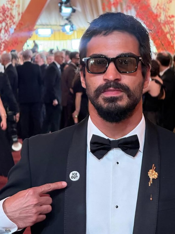 Thales Junqueira, diretor de arte de 'O Agente Secreto', com broche em protesto às políticas de Donald Trump