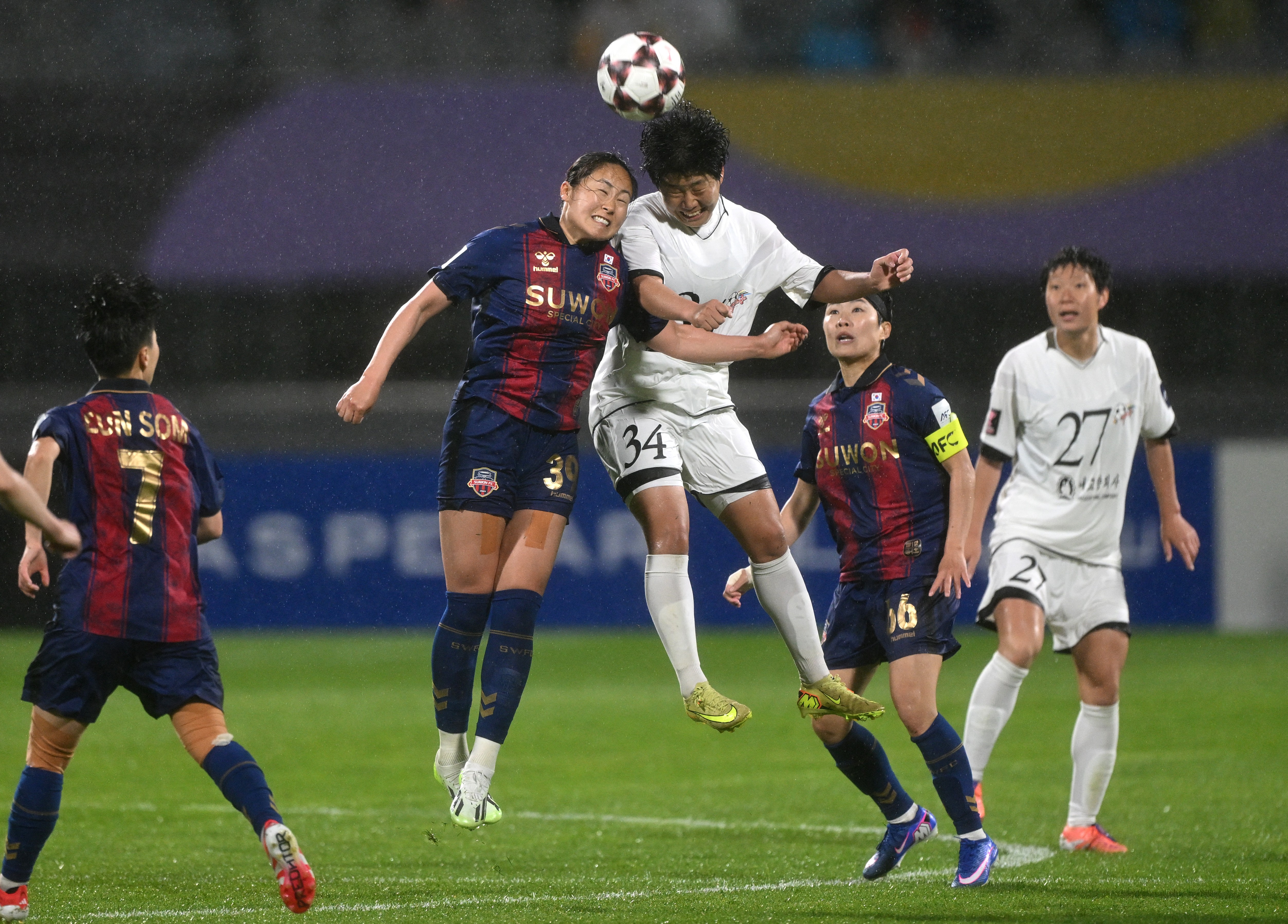 Pak Ye Gyong (C) of Naegohyang Women's FC fights for the ball with Haruhi Suzuki (2nd L) of Suwon FC Women during the AFC Women's Champions League semi-final football match between North Korea's Naegohyang Women's FC and South Korea's Suwon FC Women in Suwon on May 20, 2026. (Photo by Jung Yeon-je / AFP)