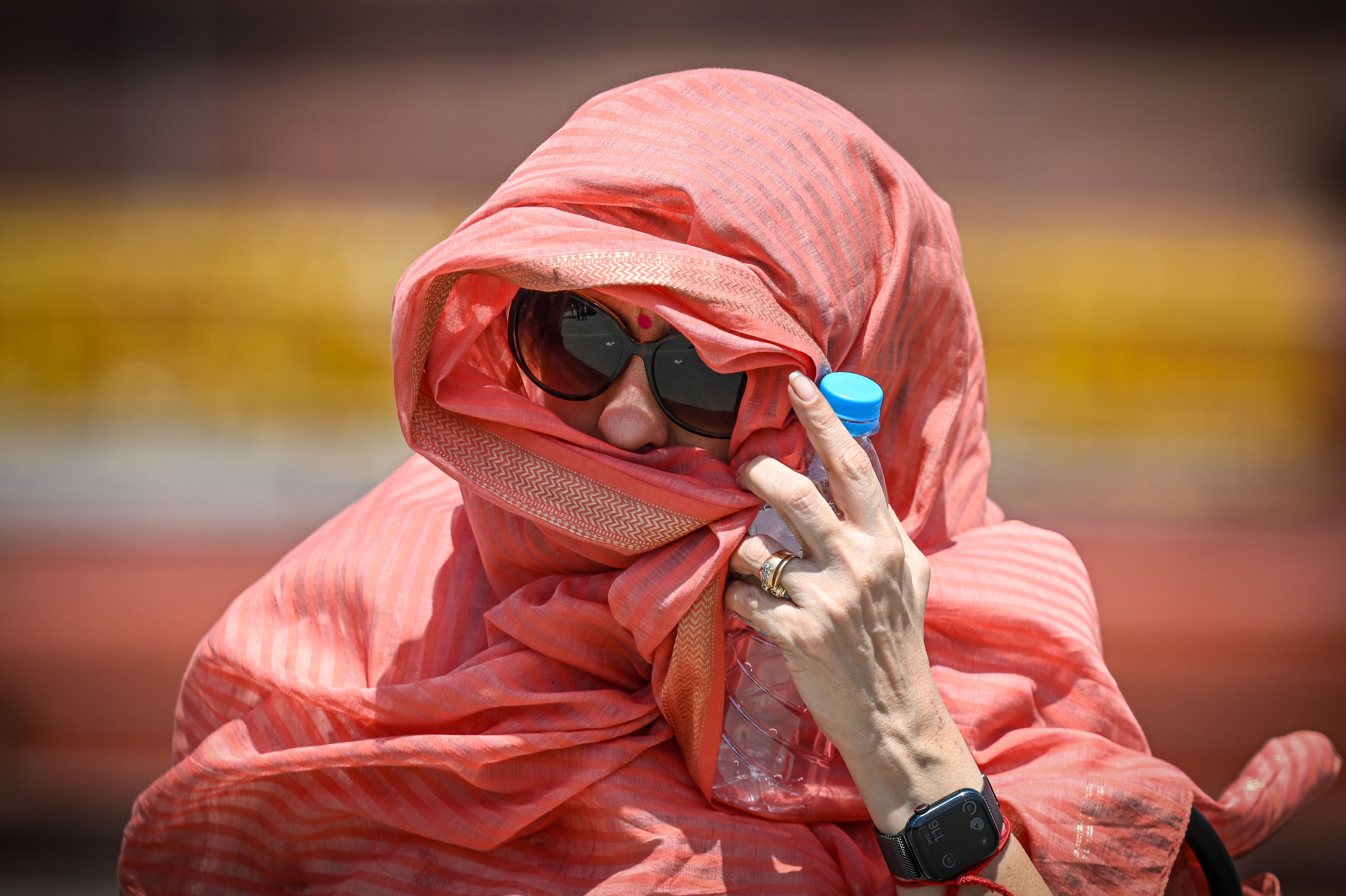 Mulher tenta proteger o rosto do calor extremo que atinge Nova Délhi, capital da Índia, em maio de 2026