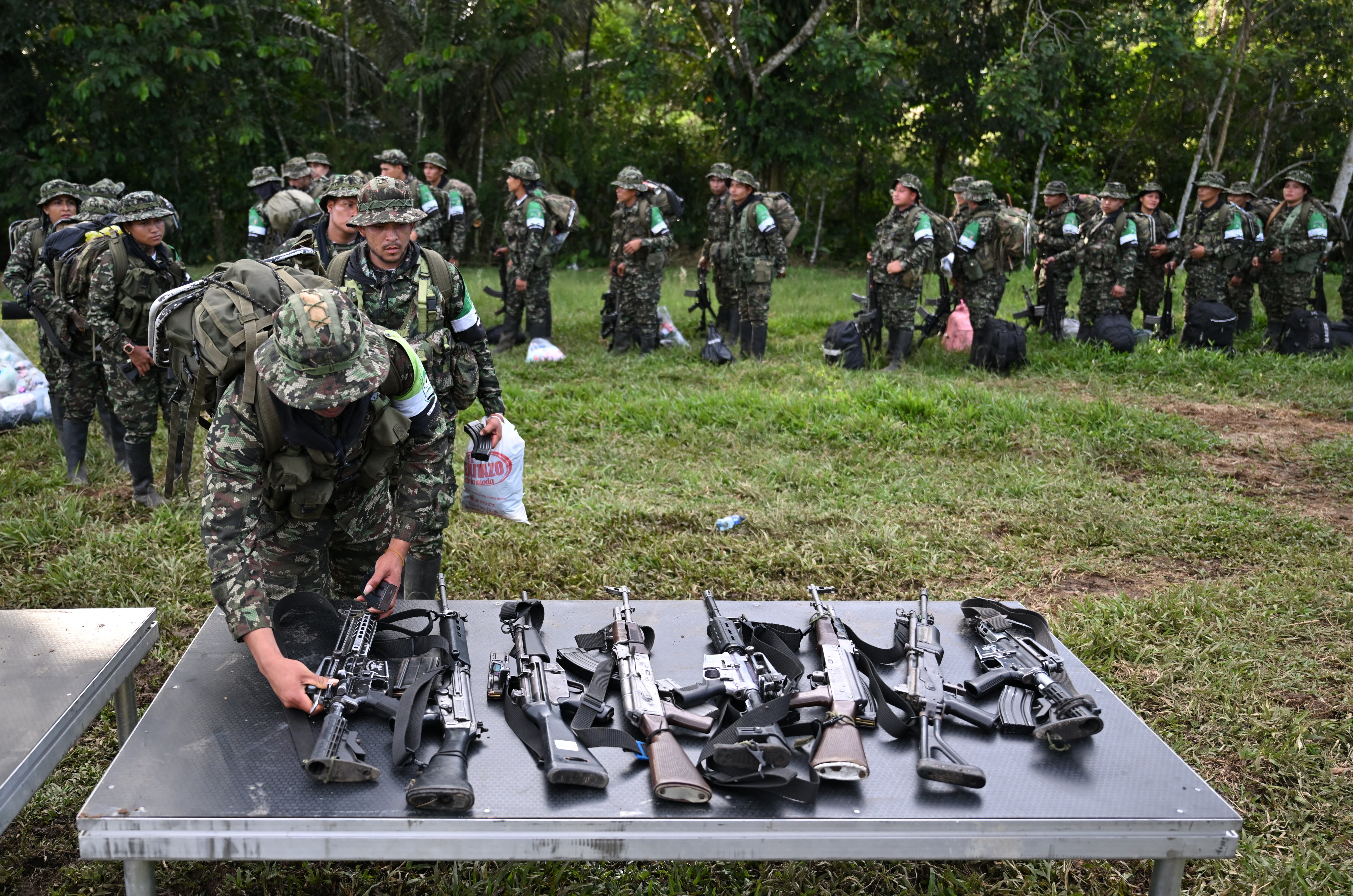 Membros do grupo Coordenadora Nacional Exército Bolivariano (CNEB) entregam suas armas em uma área de floresta no departamento de Putumayo, no sul da Colômbia, em 18 de junho de 2026.