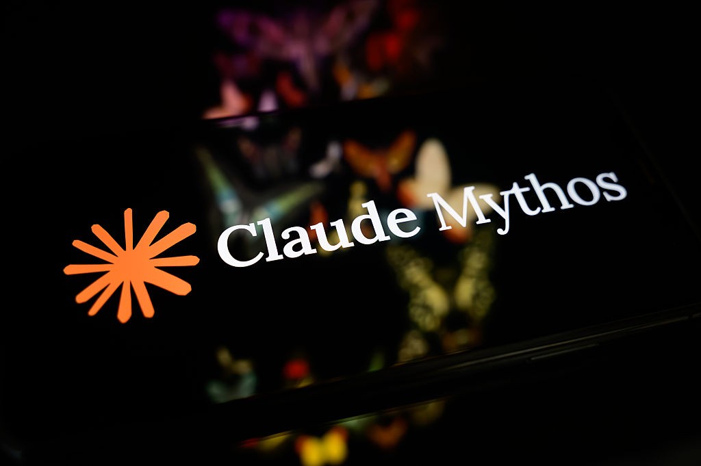 Logotipo da Claude Mythos, com um símbolo laranja de estrela ou sol à esquerda e o nome da empresa em branco à direita, sobre um fundo escuro com luzes coloridas desfocadas