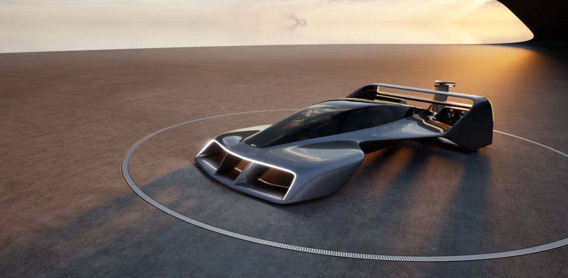 Carro conceito futurista cinza-escuro com design aerodinâmico e luzes LED brancas na frente, parado em uma plataforma circular sob um céu alaranjado ao pôr do sol