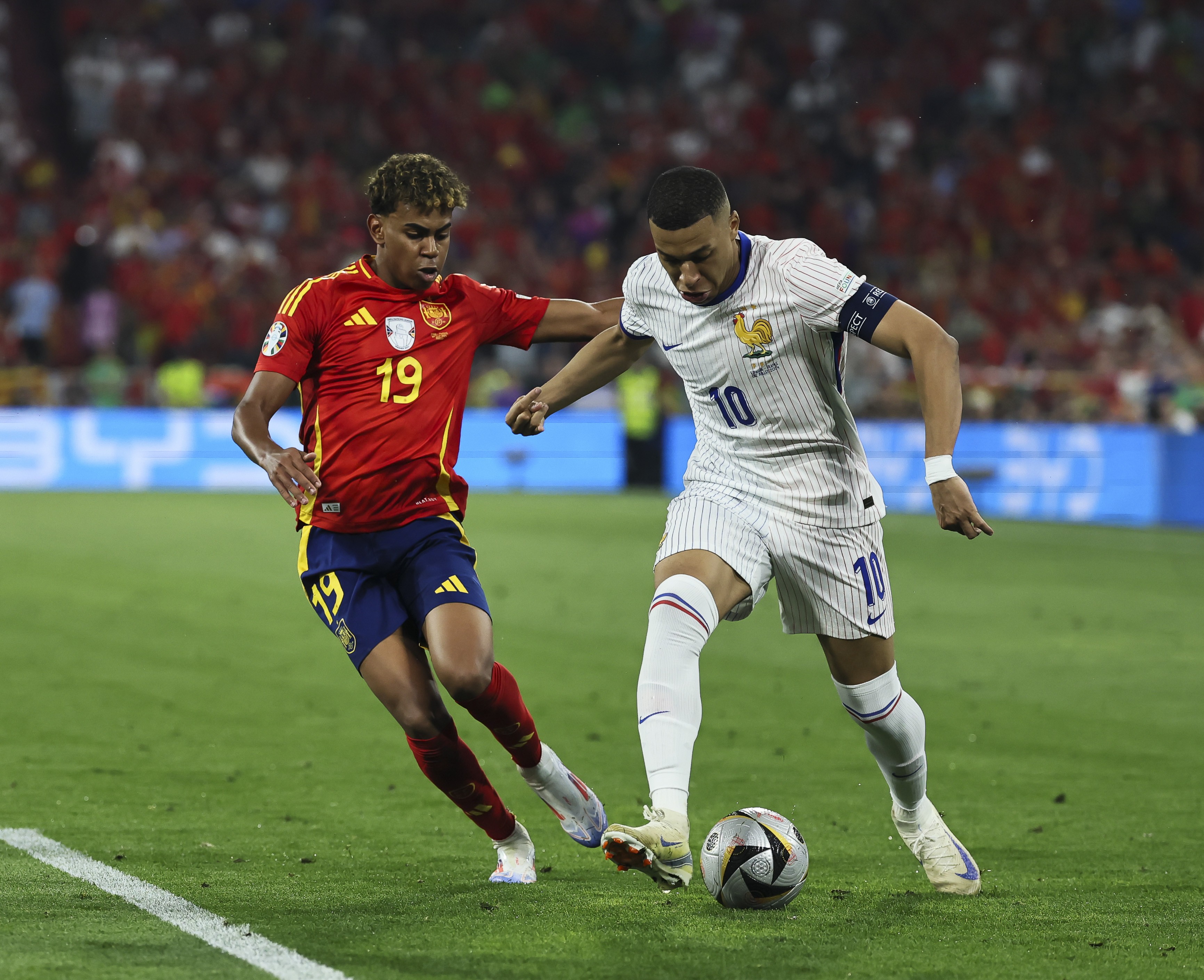 MUNICH, GERMANY - JULY 9: Lamine Yamal of Spain battles for the ball with Kylian Mbappé of France during the UEFA EURO 2024 semi-final match between Spain v France at Munich Football Arena on July 9, 2024 in Munich, Germany. (Photo by Qian Jun/MB Media/Getty Images)