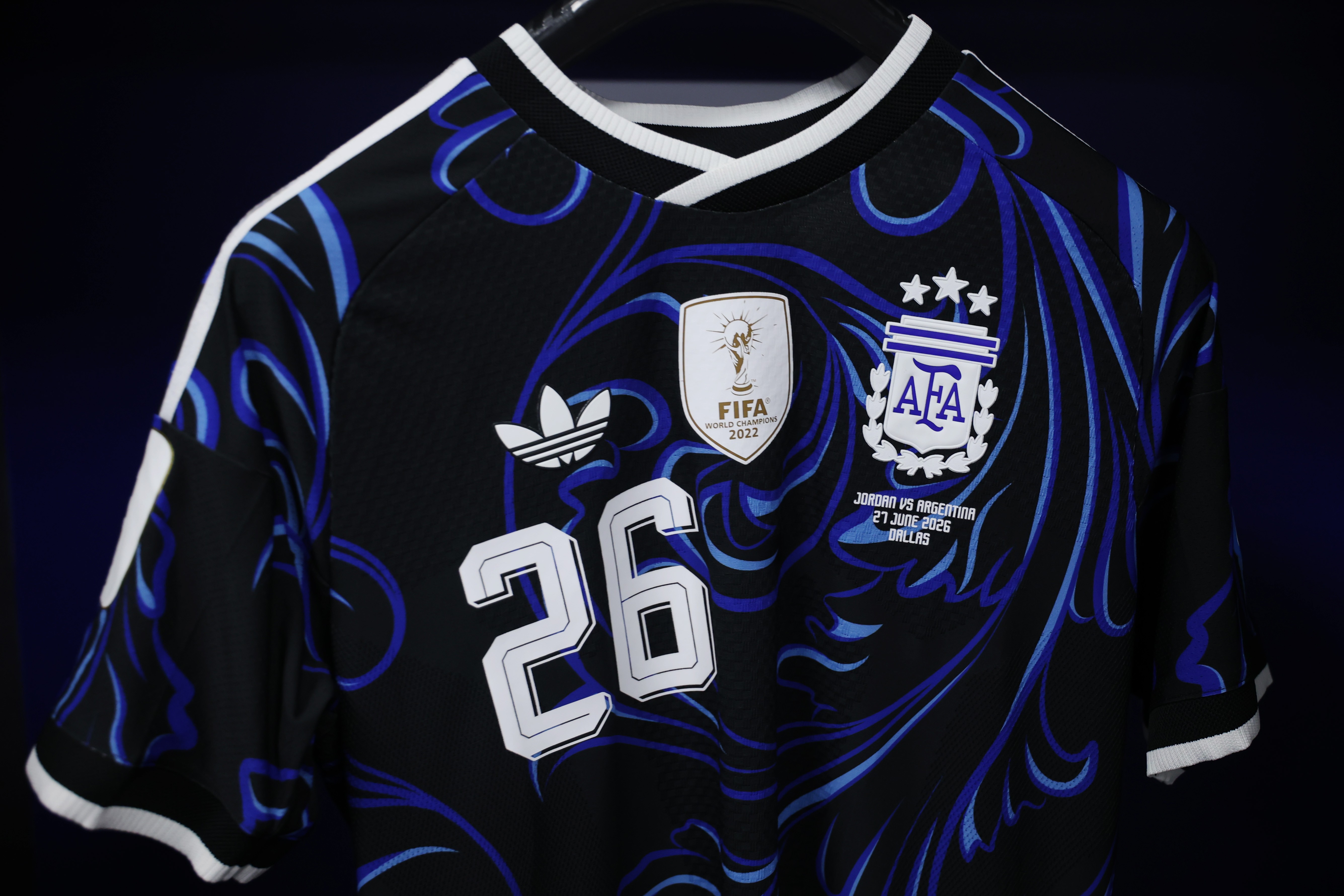 Camisa de futebol preta com detalhes em azul e branco, número 26 em destaque, escudo da FIFA e da AFA