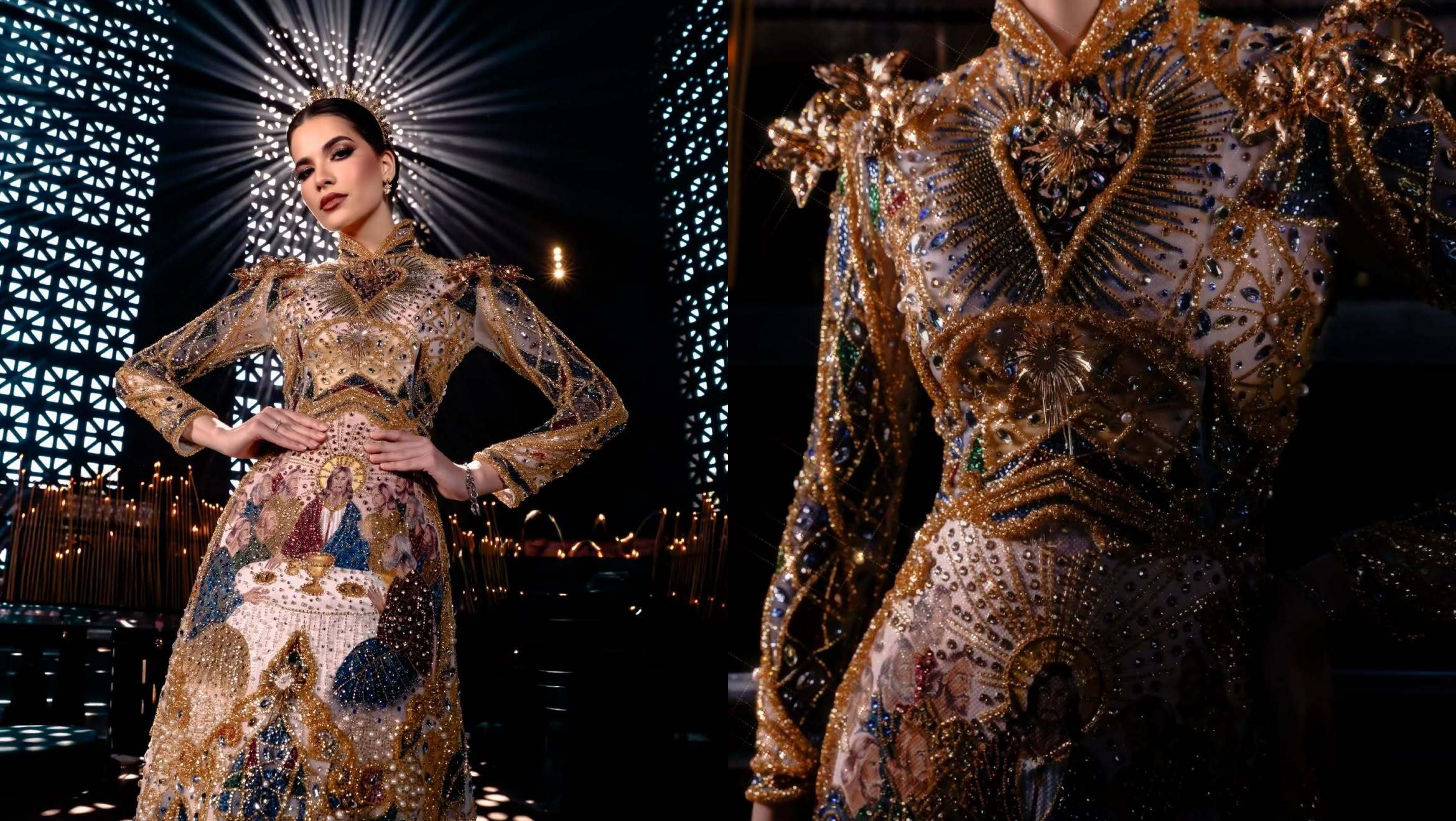 Mulher com vestido dourado e detalhes coloridos, com uma imagem da Última Ceia na saia, posa com as mãos na cintura. À direita, um manequim exibe o mesmo vestido, com detalhes bordados em ouro e pedrarias. O fundo é escuro, com iluminação em forma de raios e padrões geométricos