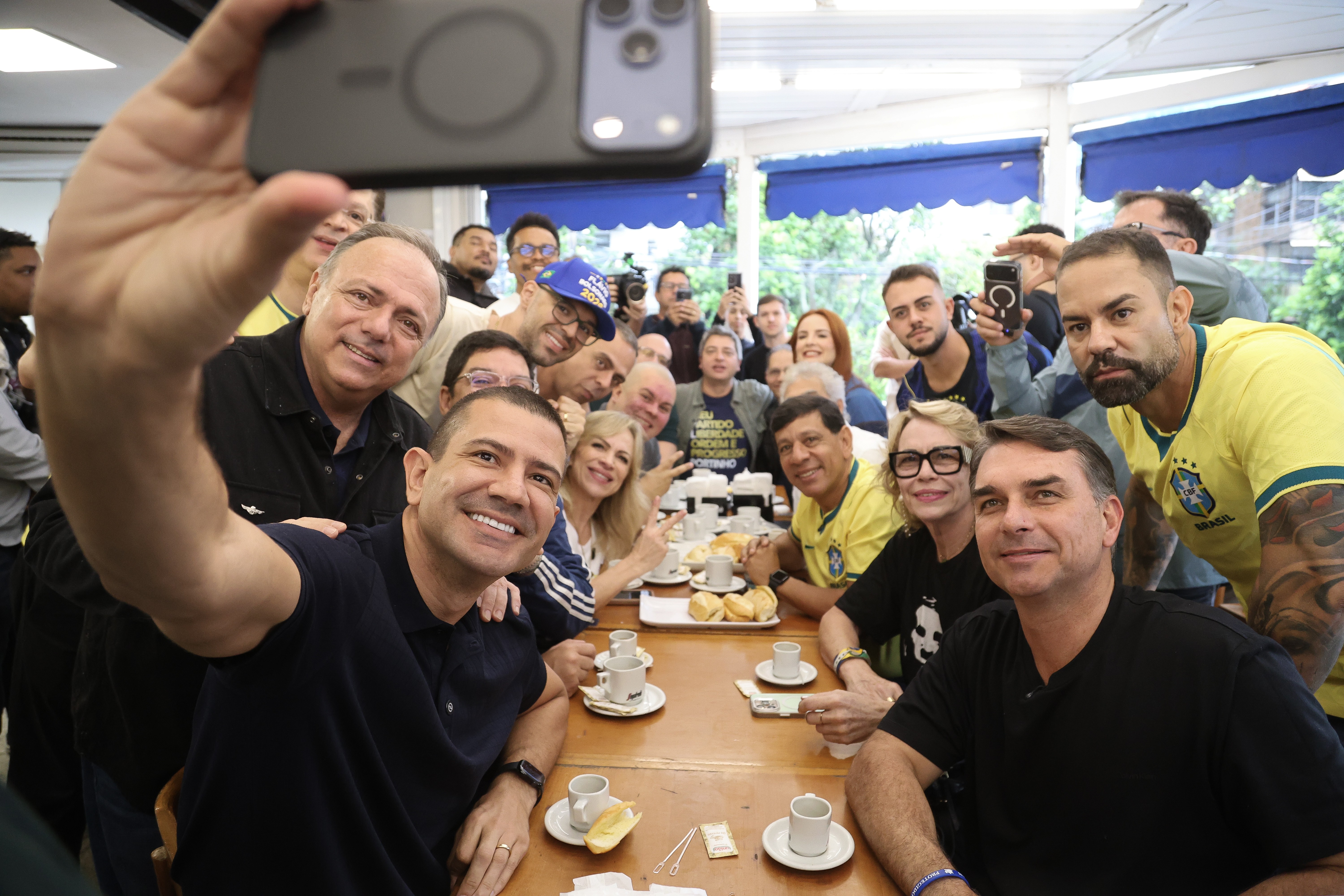 Flavio Bolsonaro, com o candidato ao governo do Rio Doulas Ruas (com o celular) e outros aliados em padaria na Barra da Tijuca, que era frequentada pelo ex-presidente Jair Bolsonaro
