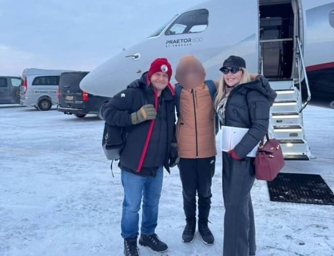 DESTINOS DE GRIFE – O filho do presidente viajou com a empresária para assistir à aurora boreal na Europa Um homem, uma mulher e um adolescente posam sorrindo em frente a um jato particular branco, modelo Praetor 600, em uma pista de aeroporto coberta de neve. O homem usa gorro vermelho, jaqueta preta e jeans. A mulher veste jaqueta preta, óculos escuros e carrega uma bolsa vinho. O adolescente, com rosto desfocado, usa jaqueta marrom.