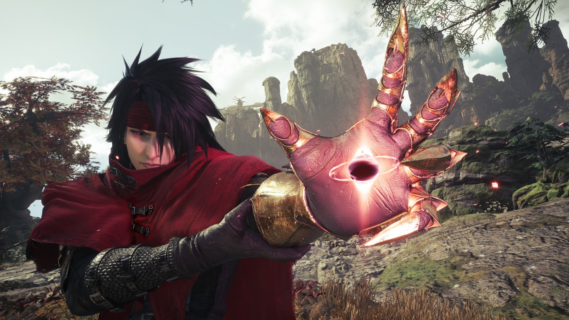 Personagem de videogame com cabelo preto espetado e bandana vermelha, vestindo capa vermelha e armadura dourada no braço esquerdo. Ele estende a mão esquerda, que brilha com energia roxa e um olho no centro da palma, em um cenário de montanhas rochosas e vegetação densa sob um céu nublado