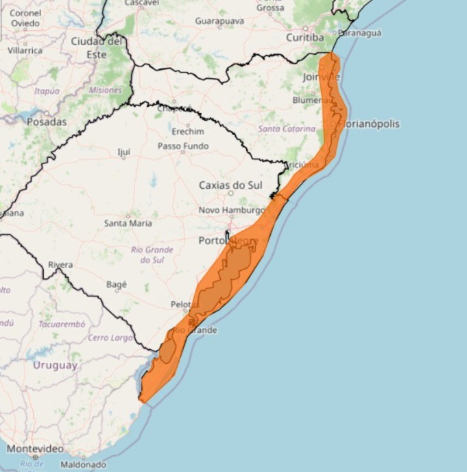 Mapa do sul do Brasil e Uruguai, mostrando uma faixa laranja ao longo da costa de Santa Catarina e Rio Grande do Sul, indicando uma área de alerta. Cidades como Porto Alegre, Florianópolis e Curitiba são visíveis