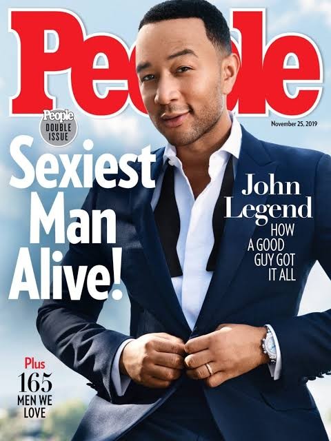 Capa da revista People com John Legend sorrindo, vestindo um terno azul-marinho, camisa branca e gravata borboleta preta, abotoando o paletó. Ele usa um relógio prateado e uma aliança. O título principal é Sexiest Man Alive!.