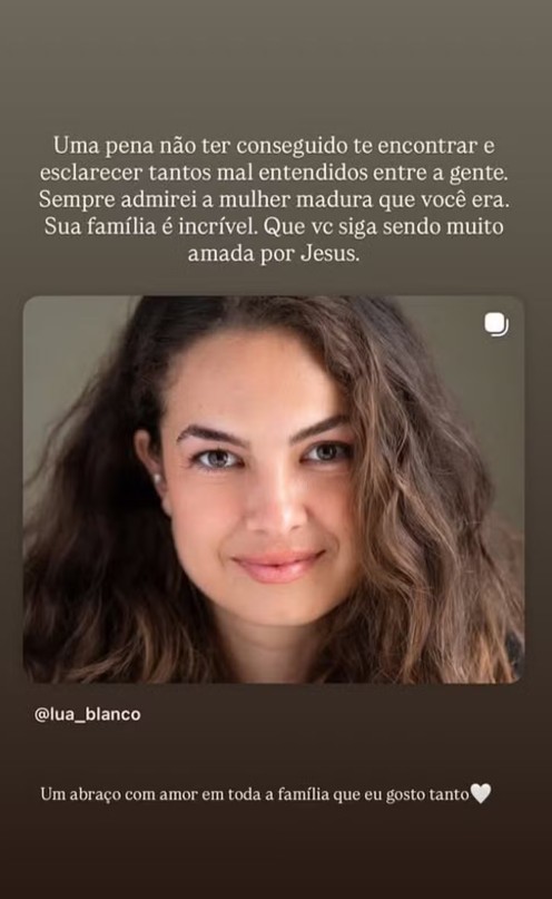 Close-up de uma mulher com cabelos castanhos ondulados e olhos claros, sorrindo gentilmente. Ela usa brincos pequenos e tem uma maquiagem leve. Acima da imagem, um texto em português lamenta não ter conseguido encontrar a pessoa e elogia sua maturidade e família. Abaixo, o nome de usuário @lua_blanco e uma mensagem de carinho para a família